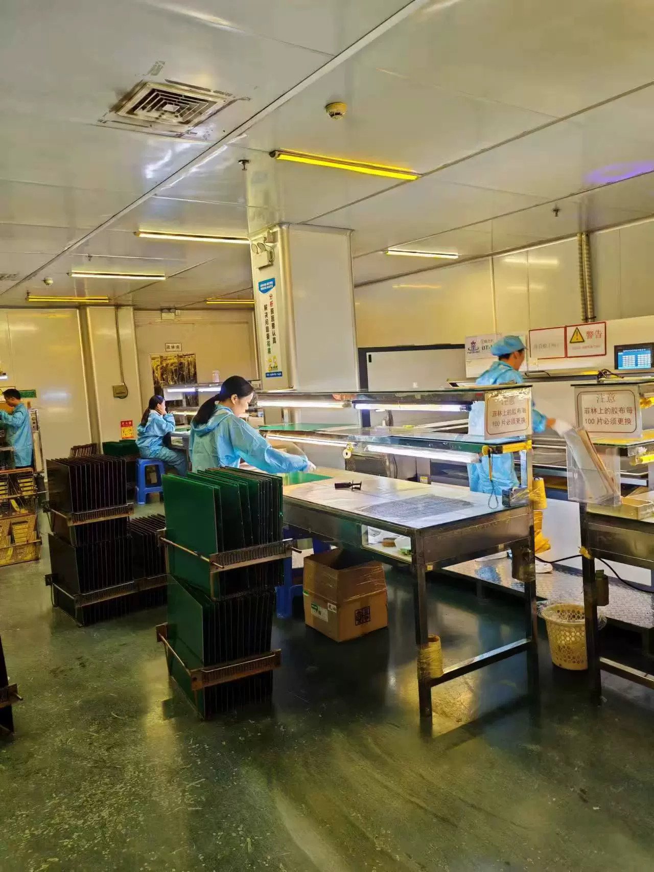 PCB production floor with technicians handling printed circuit board panels